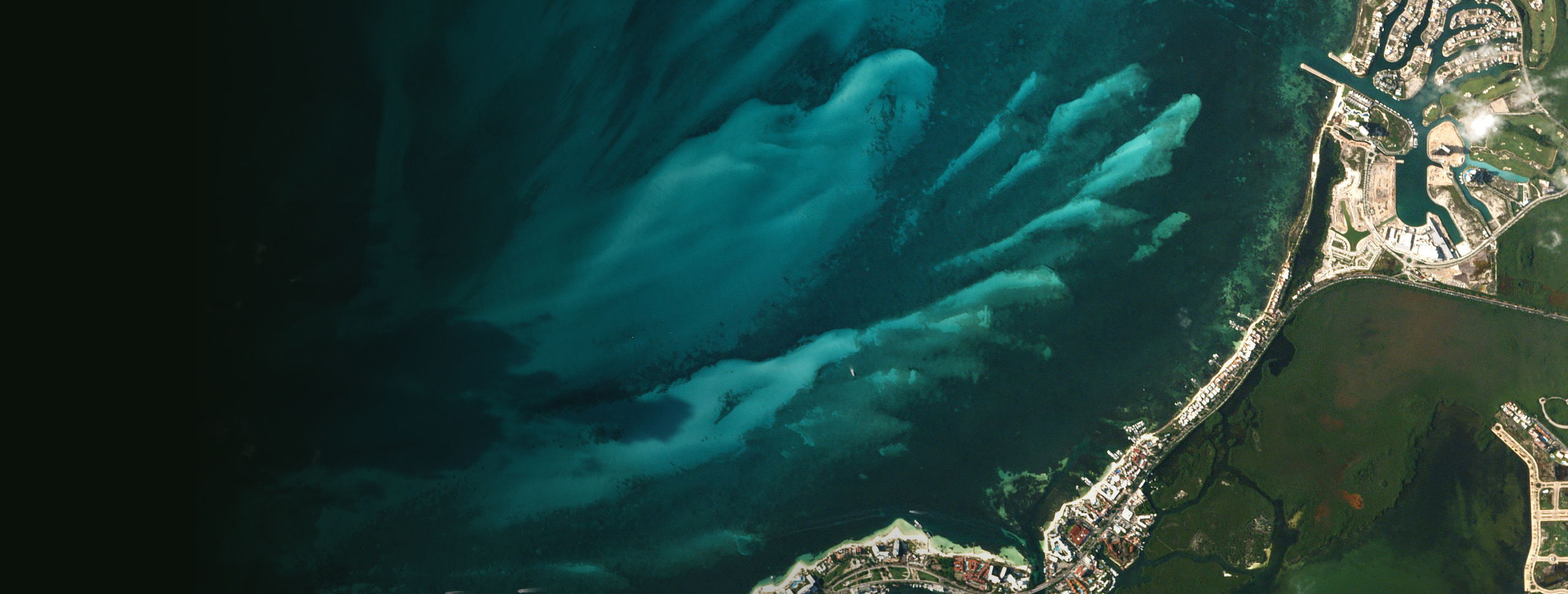 Un mapamundi en escala de grises con líneas de colores conectando varios puntos